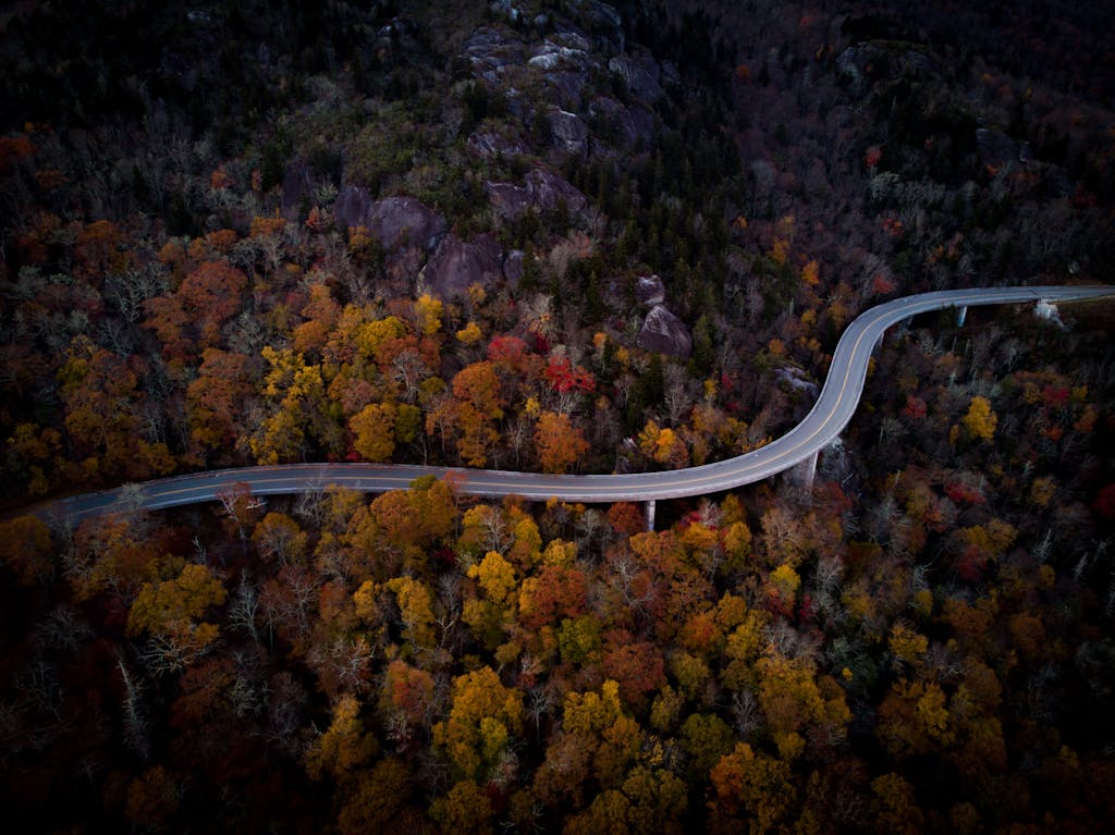 Stunning aerial view of a winding road surrounded by vibrant autumn foliage in Boone, NC.